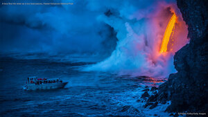 A lava flow hits water as a tour boat passes, Hawaii Volcanoes National Park