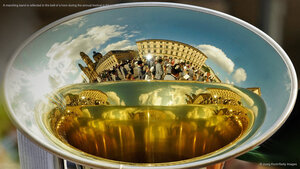 A marching band is reflected in the bell of a horn during the annual festival in Munich, Germany