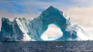 Natural arch carved in an iceberg, Antarctica
