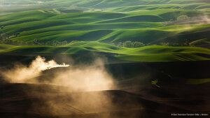 A tractor kicks up dust while tilling fields on the Palouse near Pullman, Washington