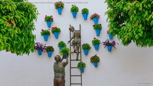 Bronze sculpture of a child and his grandfather caring for plants and flowers in the San Basilio neighborhood of Córdoba, Spain