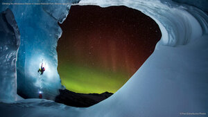 Climbing the Athabasca Glacier in Jasper National Park, Alberta, Canada, as the aurora borealis glows