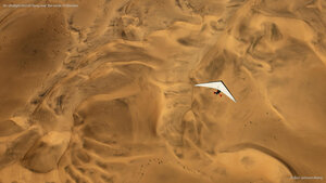 An ultralight aircraft flying over the sands of Namibia