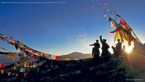 Pilgrims throwing wind horses into the air above Ganden Monastery for the New Year in Tibet, China