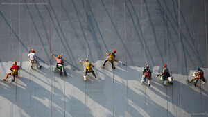 Workers applying stucco to a wall of a new building